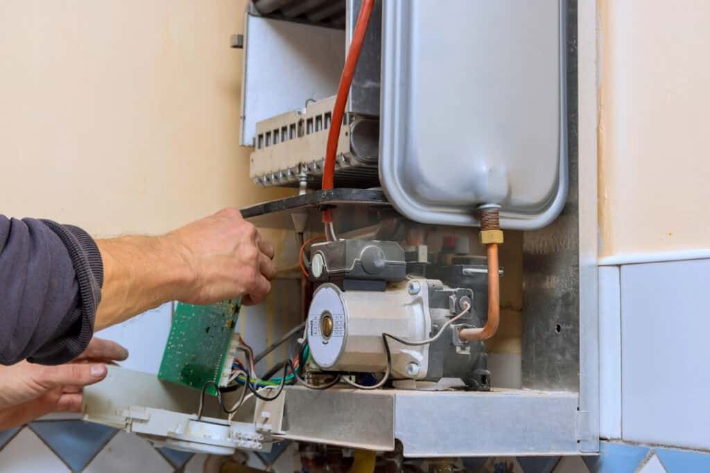 - Hand repairing electrical component of a boiler or gas water heater.
